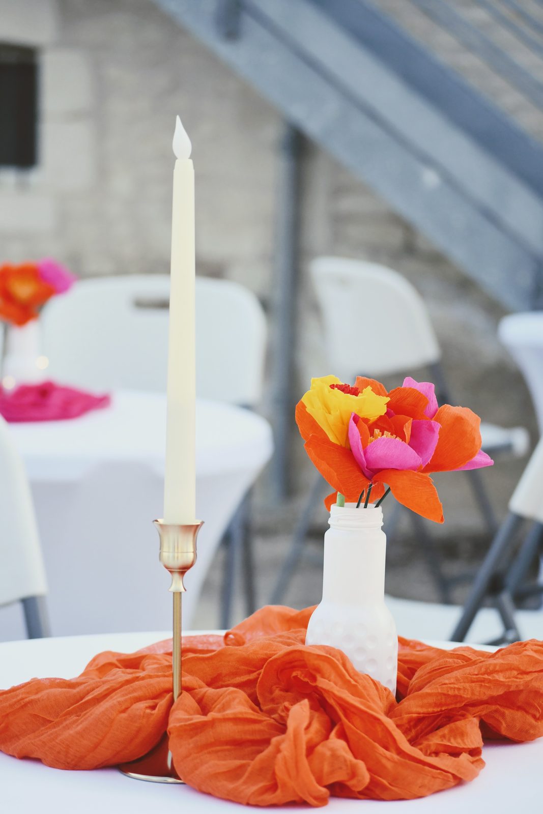 Bougie et fleurs en papier sur un voile orange