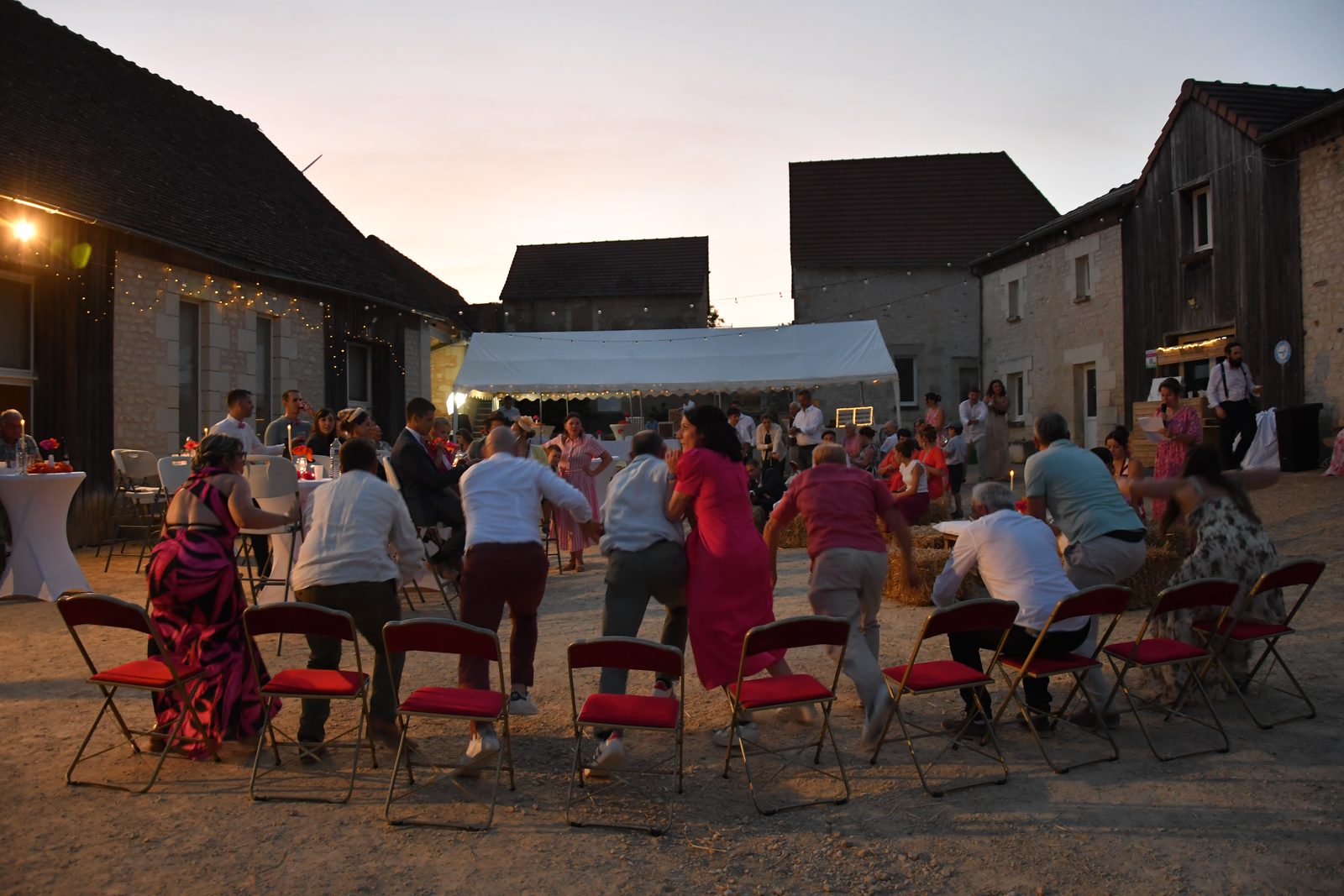 Soirée de mariage dans la cour d’une ferme, sous le chapiteau